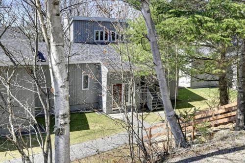 a house with a red door and some trees at Tremblant Ski Condo, Fast WIFI & Free parking in Mont-Tremblant