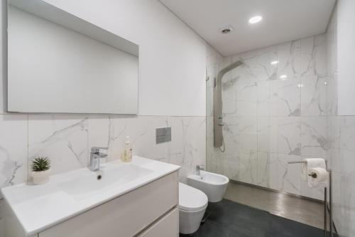 a white bathroom with a sink and a toilet at PALHOTAS GUEST HOUSE - Apartamento Sameiro in Braga