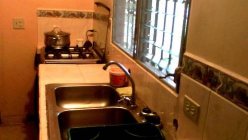 a kitchen with a sink and a stove at PaCasa Hostel in David