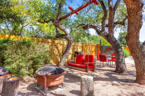 a backyard with a fire pit and chairs and a fence at Happy Hideaway in Wimberley