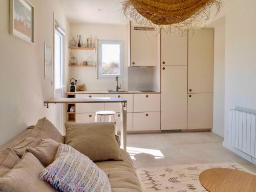 a living room with a couch and a kitchen at Palmito in Bidart