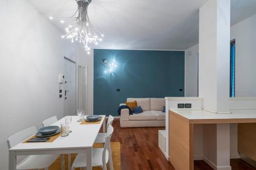 a kitchen and living room with a white table and chairs at La Casetta di Gio in Busnago