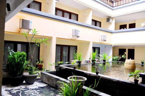a courtyard of a building with a koi pond at Nirmala Hotel & Convention Centre in Denpasar
