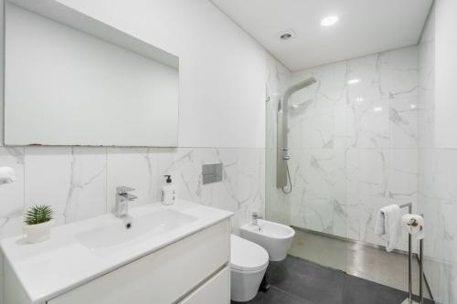 a white bathroom with a sink and a toilet at PALHOTAS GUEST HOUSE - Apartamento Palhotas in Braga