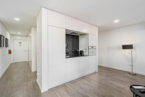a living room with white walls and wooden floors at PALHOTAS GUEST HOUSE - Apartamento Palhotas in Braga
