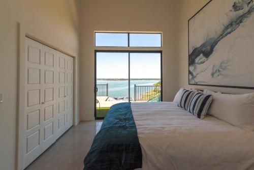 a bedroom with a bed with a view of the ocean at Happy Owl Lakehouse in Canyon Lake