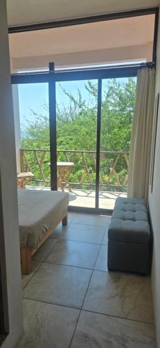 a bedroom with a bed and a large glass window at Casa Laud Cuarto Guamuchil in Guayabas