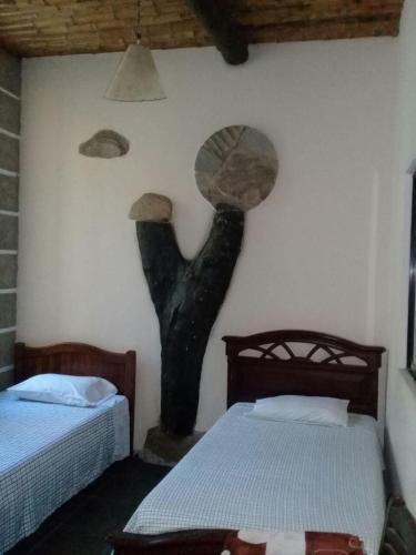 a sculpture of a head on a wall next to two beds at Villa Rossy in Samaipata