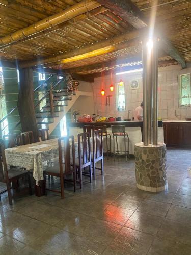 a dining room with a table and chairs and a kitchen at Villa Rossy in Samaipata