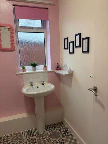 a pink bathroom with a sink and a window at Blackpool Rocks Pleasure Beach in Blackpool