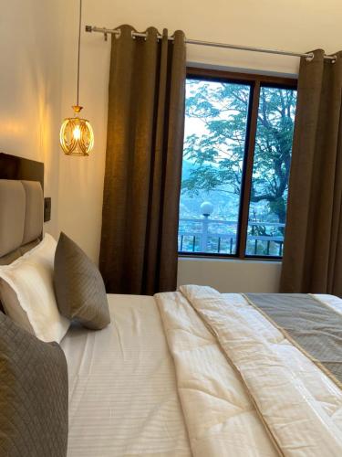a bedroom with a bed with a large window at Himalaya View Resort in Barkot