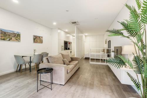 a living room with a couch and a table at PALHOTAS GUEST HOUSE - Apartamento Jardim Santa Bárbara in Braga