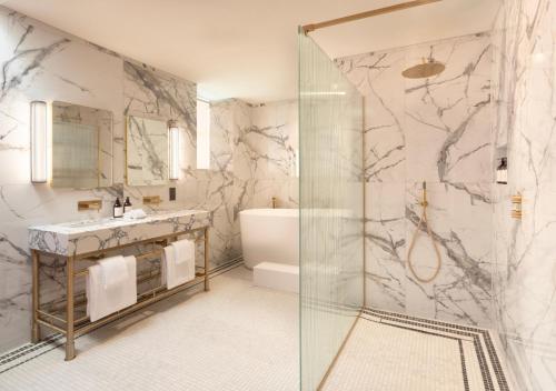 a bathroom with a shower and a tub and a sink at JA Mar Hall Glasgow Scotland in Bishopton