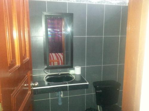 un baño con lavabo y espejo en Hostal Selvatrip, en Leticia