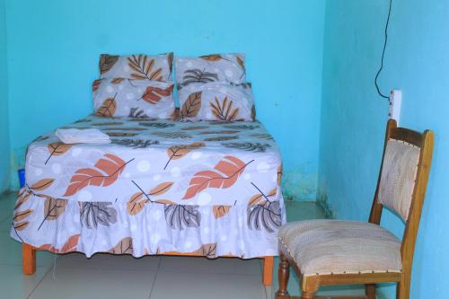 a blue room with a bed and a chair at Equatorial Guest House in Rustenburg