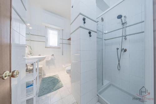 a white bathroom with a shower and a toilet at Sea Dream - Vista Mare - Giardino - Box Privato in Bergeggi