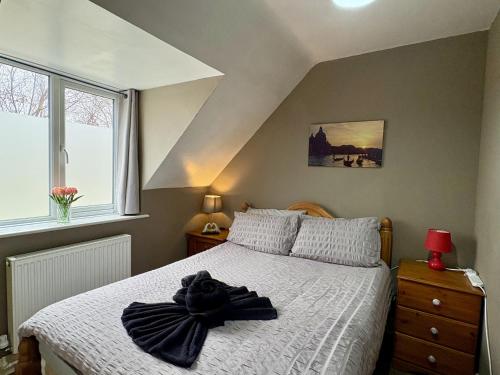 a bedroom with a bed with a black hat on it at Travellers Rest Motel in Ingoldmells
