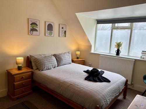 a bedroom with a bed with a black teddy bear on it at Travellers Rest Motel in Ingoldmells