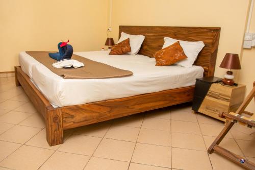 a bedroom with a large wooden bed with pillows at Chez Jenny port Mathurin in Rodrigues Island