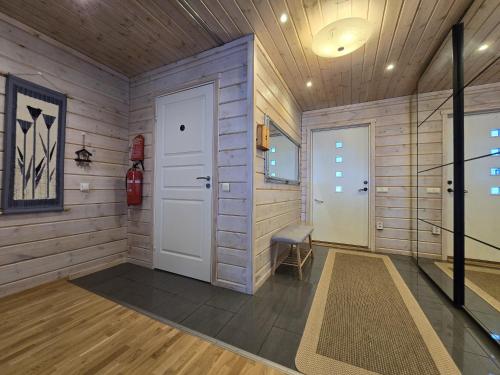 a hallway with a white door and a stair case at Orava Järven Talo in Ranua