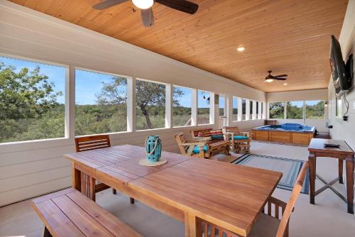 eine überdachte Veranda mit einem Holztisch und Stühlen in der Unterkunft Fox Trot in Canyon Lake