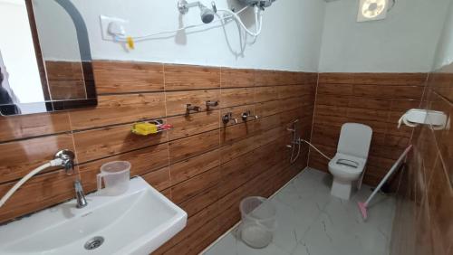 a bathroom with a sink and a toilet and a mirror at Himalaya View Resort in Barkot