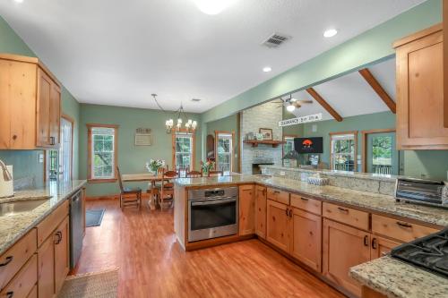 a large kitchen with wooden cabinets and wooden floors at Fairlawn on the Blanco in Wimberley