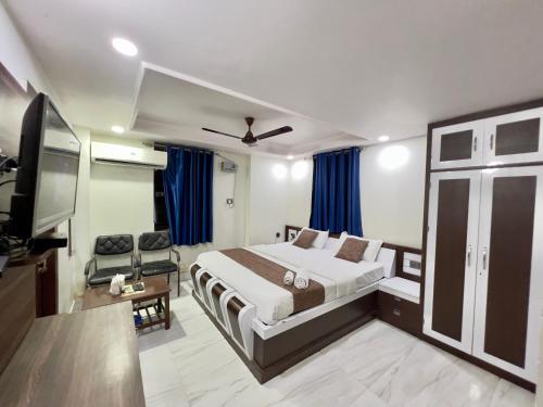 a hotel room with a bed and a flat screen tv at Hotel Aman in Patna