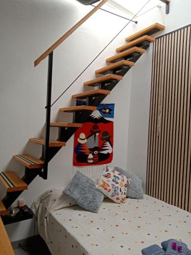 a bedroom with a bed and a spiral staircase at Casa Klemann with private sun terrace in Cruce de Arinaga