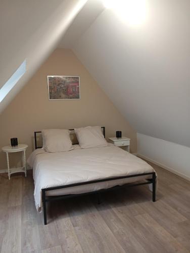 a bedroom with a bed in a attic at Le gîte 1869 in Clarques