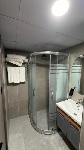 a bathroom with a shower and a sink at Dostlar Hotel in Mersin