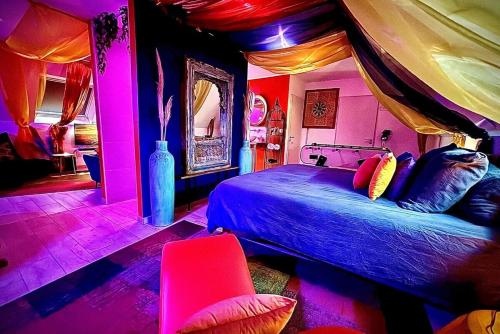 a bedroom with a bed in a room with pink lights at NÜ-DE GITES ET SPA in Zuydcoote