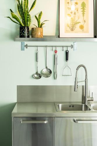 a kitchen with a sink and some plants on a shelf at Ferox Stay in Varsenare