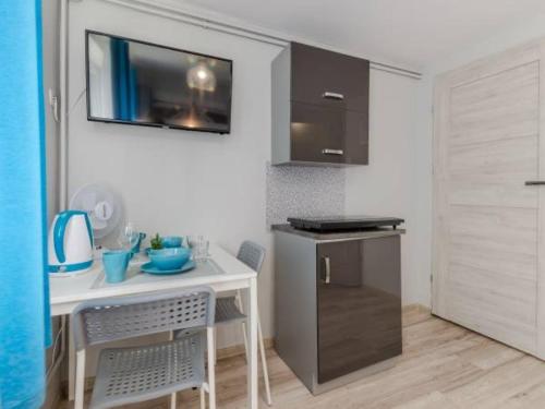 a small kitchen with a small table and a small refrigerator at Spełniony sen in Stegna