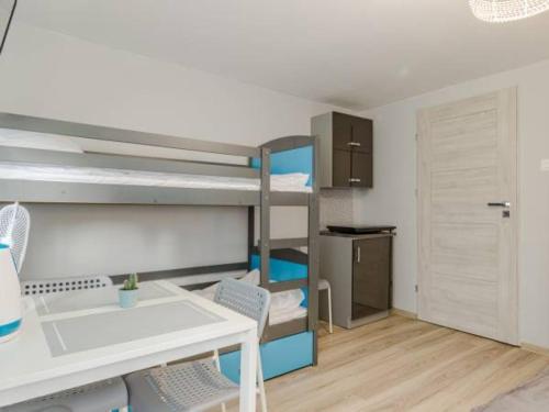 a small room with bunk beds and a table and chairs at Spełniony sen in Stegna