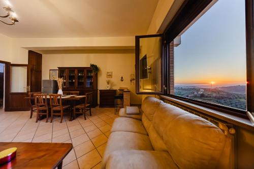 ein Wohnzimmer mit Sofa und großem Fenster in der Unterkunft Casa Stefano in Casperia