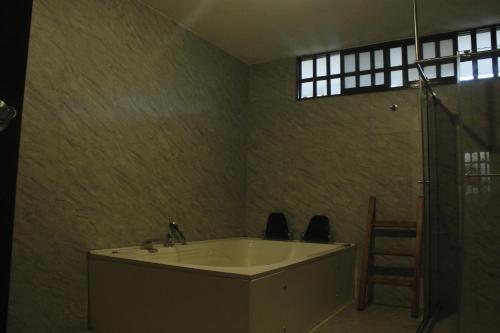 a bath tub in a room with a ladder and a window at Cabaña Barichara in Barichara