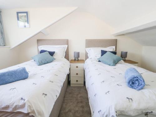 two twin beds in a room with white walls at Yewbarrow in Seascale