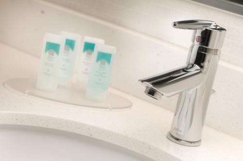 a bathroom sink with a faucet and three tubes of toothpaste at SpringHill Suites Alexandria in Alexandria