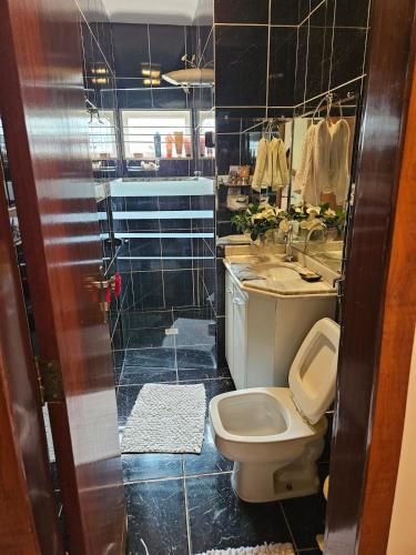 a bathroom with a toilet and a sink at Corpo Arte Acomodação in Goiânia