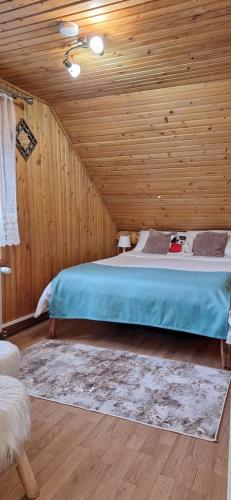 a bedroom with a bed in a wooden room at Pensiunea Floarea Dornei in Şarul Dornei