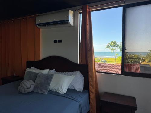 a bedroom with a bed with a view of the ocean at Brisa marina in Moín