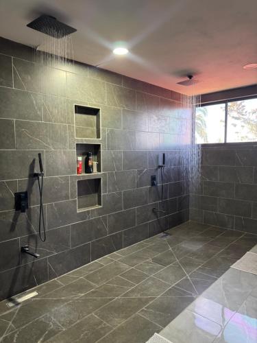 a bathroom with a shower with gray tiles at Brisa marina in Moín