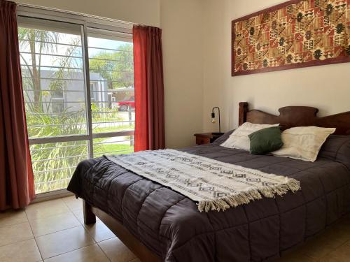 a bedroom with a bed and a large window at Departamentos Equipados Realico in Realicó