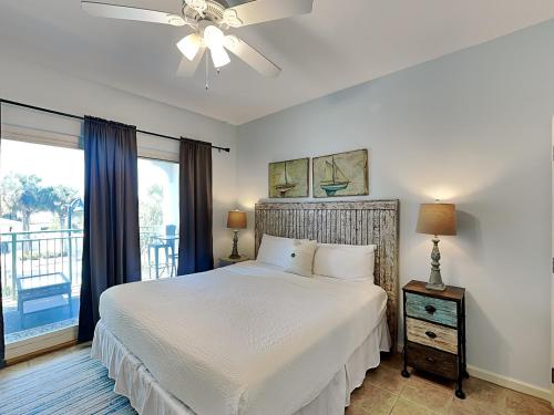a bedroom with a white bed and a balcony at Inn at Seacrest #206 in Rosemary Beach