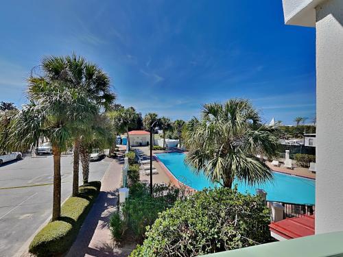 a view of a swimming pool with palm trees at Inn at Seacrest #206 in Rosemary Beach
