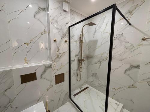 a bathroom with a shower with marble walls at Vert Unique Luxury Experience in Băile Felix in Baile Felix