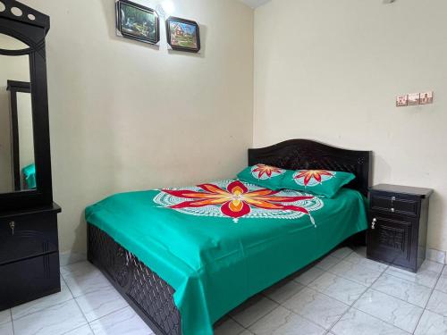 a bedroom with a bed with a green comforter at Sylhet three bedroom apartment in Sylhet