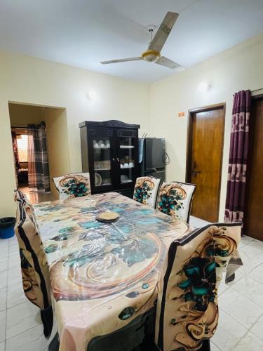 a dining room with a table and four chairs at Sylhet three bedroom apartment in Sylhet