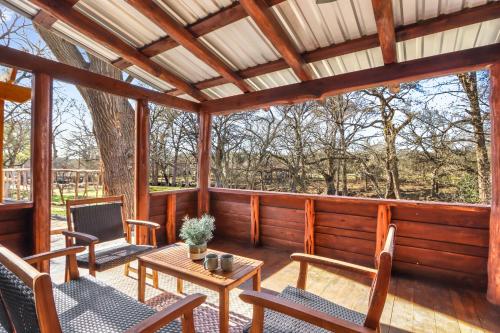 a screened in porch with chairs and a table at Dew Drop Inn in Wimberley